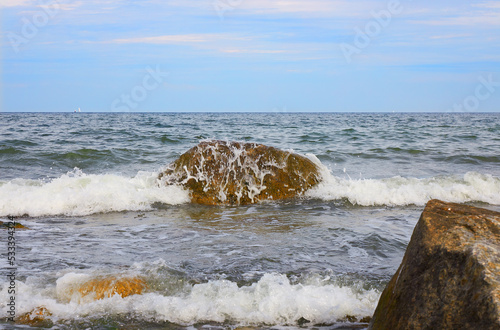 Wellen an dem Ostseestrand bei blauem Himmel