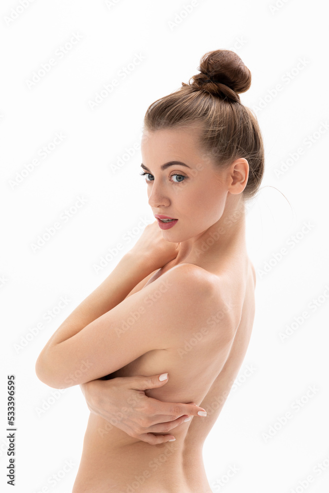Obraz premium Beautiful topless young woman hugging herself by the shoulders and posing for the camera