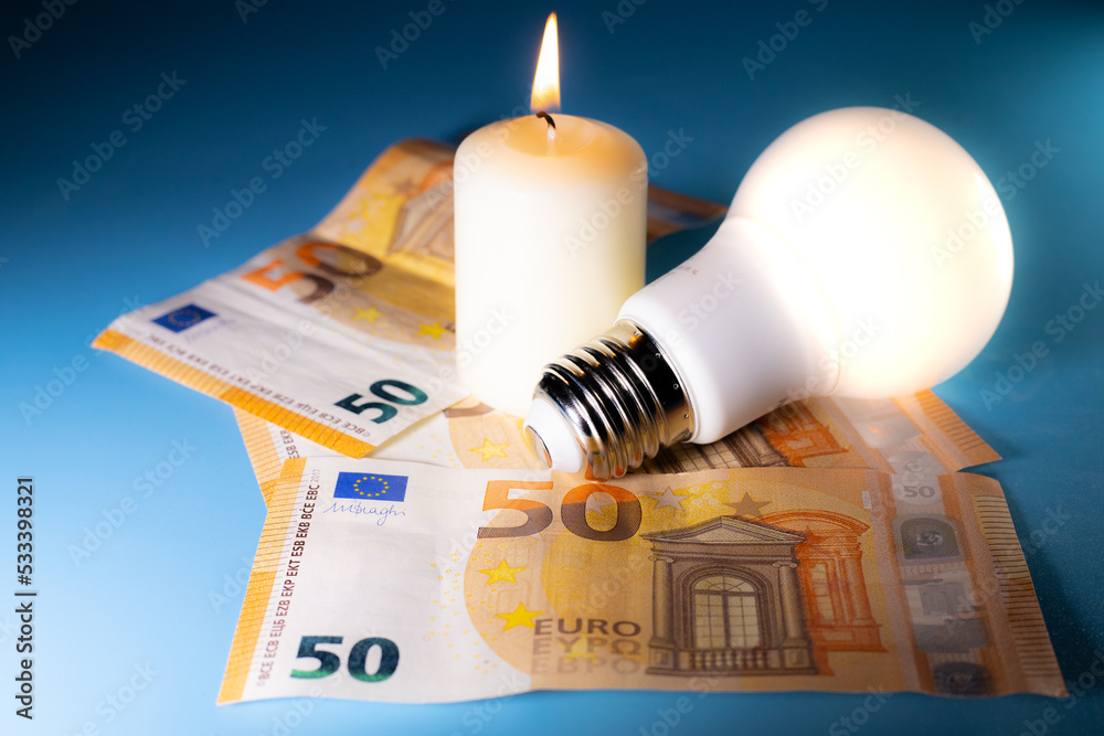 Energy price increase. Burning candles with an incandescent bulb on euro money. Increase in energy bill prices.