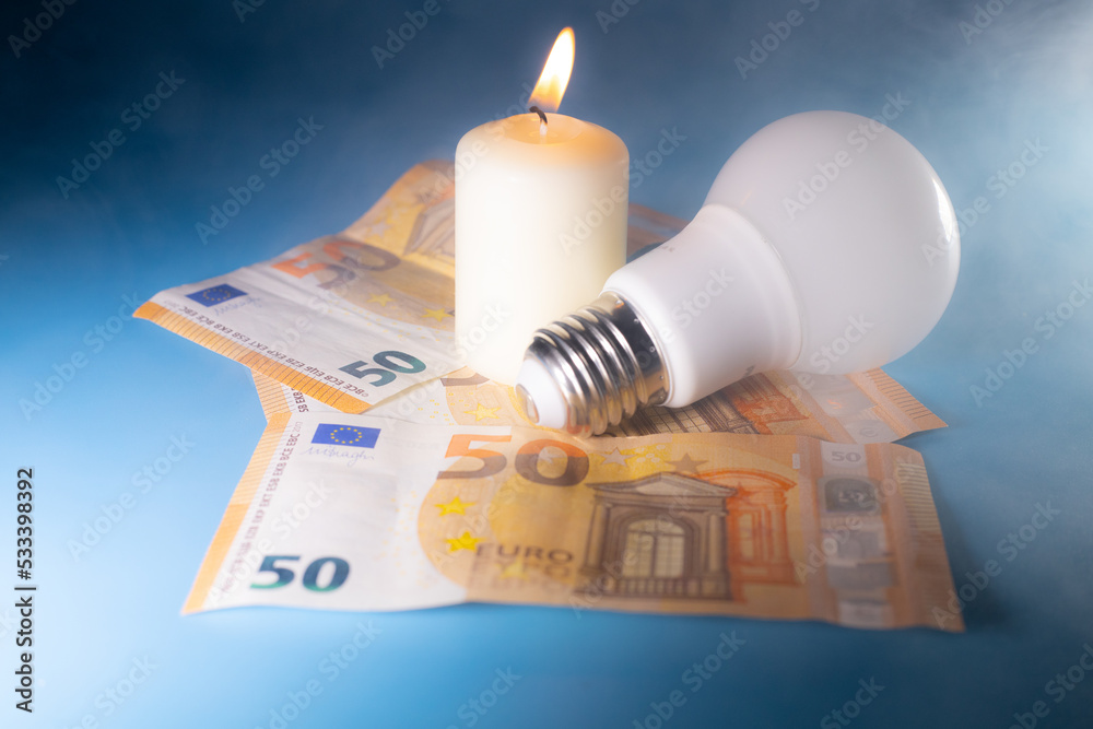 Energy price increase. Burning candles with an incandescent bulb on euro money. Increase in energy bill prices. Energy price increase. Burning candles with an incandescent bulb on euro money. Increase in energy bill prices.
