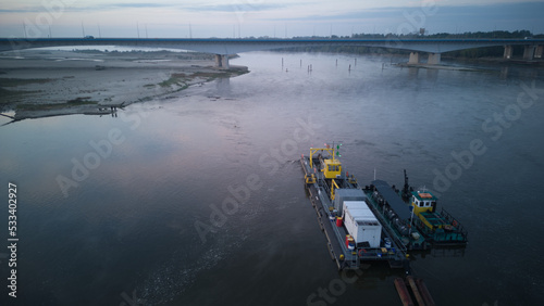 A River Dredger on a river during a misty dusk. Aerial view. 