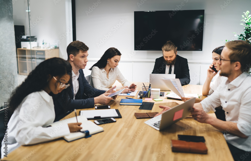 Group of colleagues discussing project in boardroom Group of colleagues discussing project in boardroom