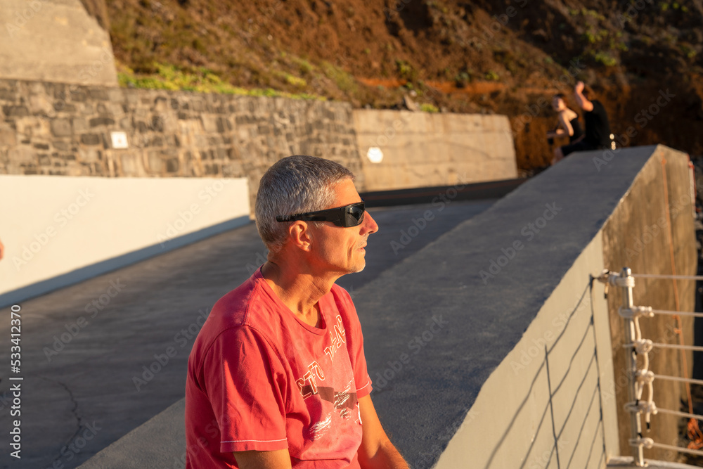 Mesmerized man looking at sunset on a beautiful island Mesmerized man looking at sunset on a beautiful island