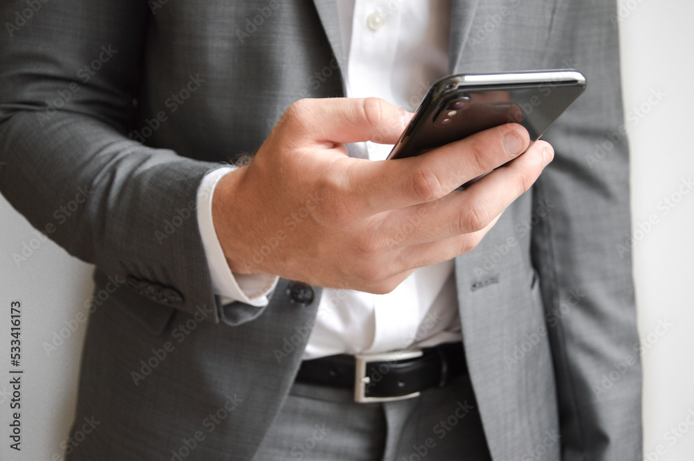 Midsection of businessman holding a mobile phone Midsection of businessman holding a mobile phone