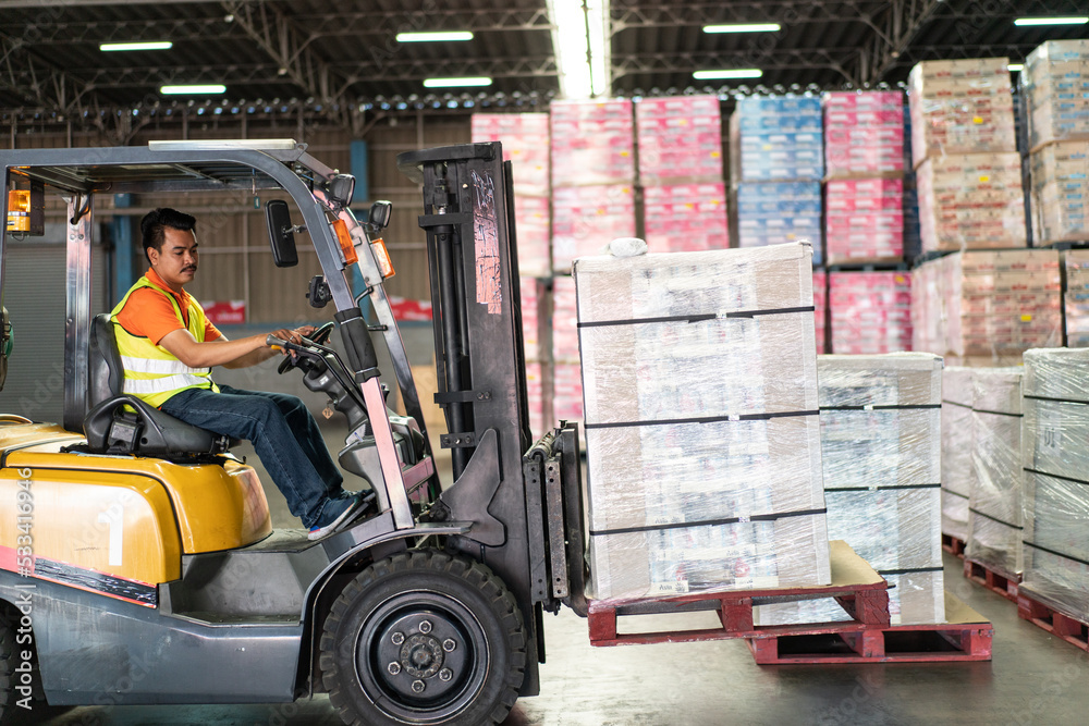 Asian male driver driving forklift loading parcel box to shipping delivery in the warehouse distribution. import export logistic career, worker working at industrial factory. Asian male driver driving forklift loading parcel box to shipping delivery in the warehouse distribution. import export logistic career, worker working at industrial factory.