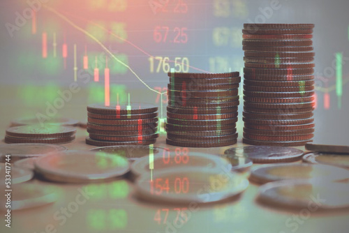 Close up of hand putting coins increase arranged on table. Coin stack or trader is showing a growing virtual hologram stock, invest in trading.