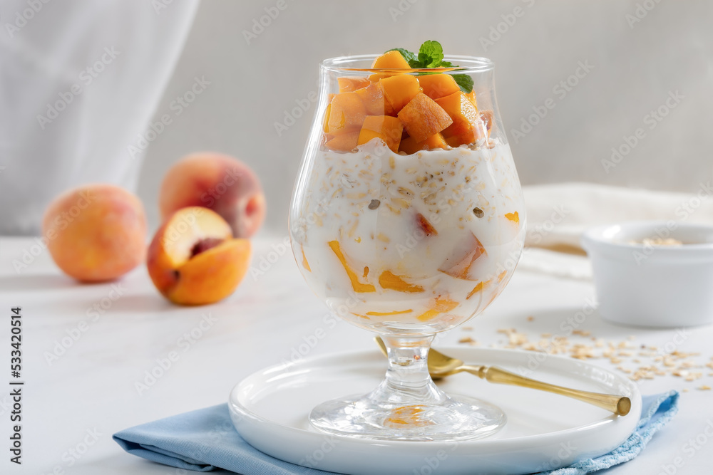 Peaches and Cream Overnight Oats. Healthy breakfast made with oats soaked for the night in milk or yogurt layered with cubes of fresh peaches, served in a clear glass. Peaches and Cream Overnight Oats. Healthy breakfast made with oats soaked for the night in milk or yogurt layered with cubes of fresh peaches, served in a clear glass.