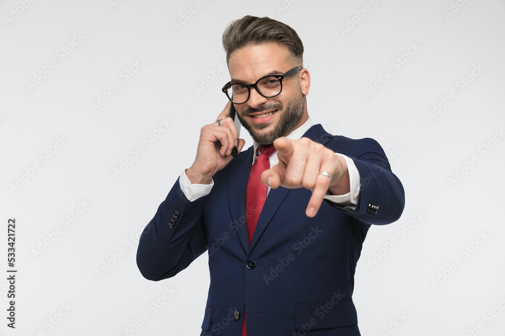 smiling businessman with glasses having a conversation and pointing finger smiling businessman with glasses having a conversation and pointing finger