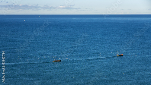 two boats with fishermen sail to fish in the sea © kirillk