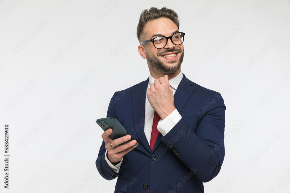 happy businessman holding phone, looking away and smiling happy businessman holding phone, looking away and smiling