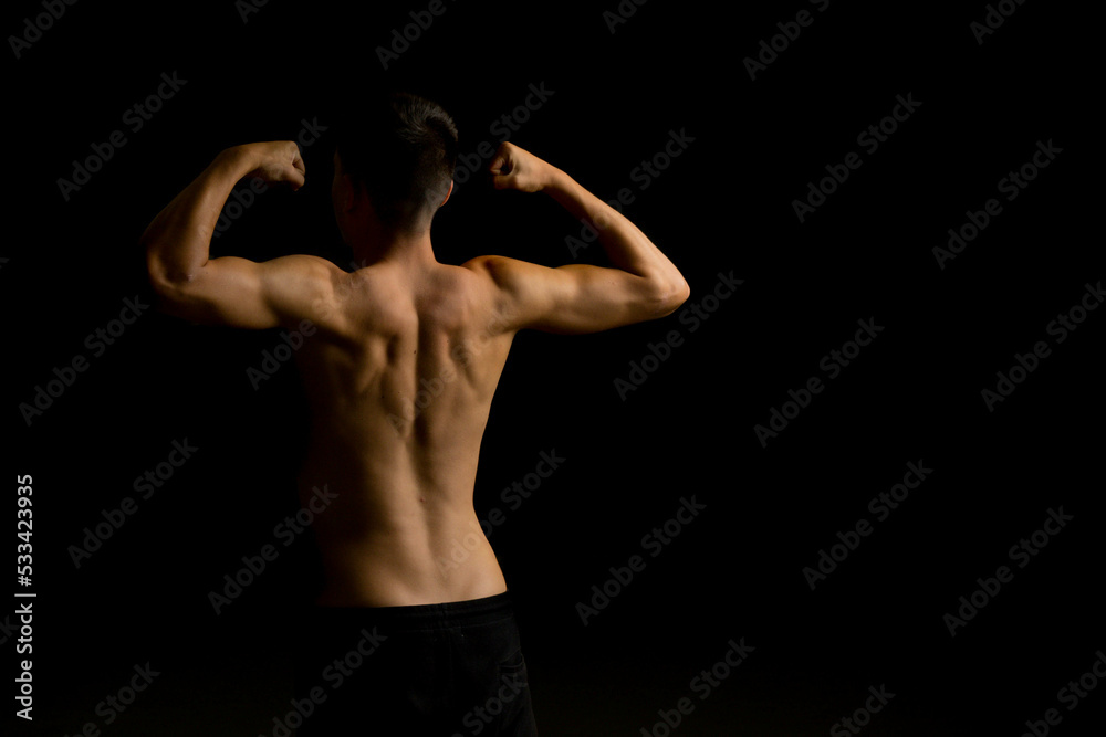 Nineteen year old teen boy flexing his back Nineteen year old teen boy flexing his back