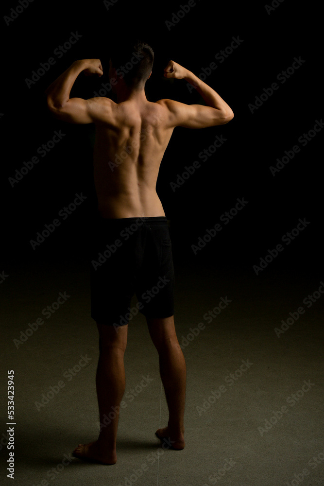 Nineteen year old teen boy flexing his back Nineteen year old teen boy flexing his back