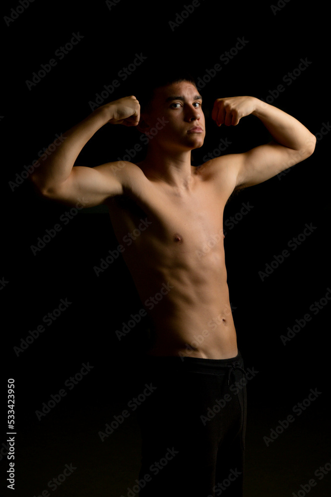 Nineteen year old teen boy flexing his arms Nineteen year old teen boy flexing his arms