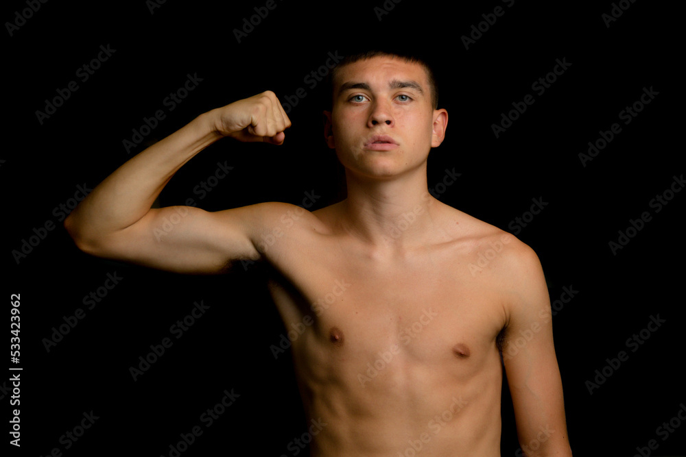 Nineteen year old teen boy flexing his arm muscles