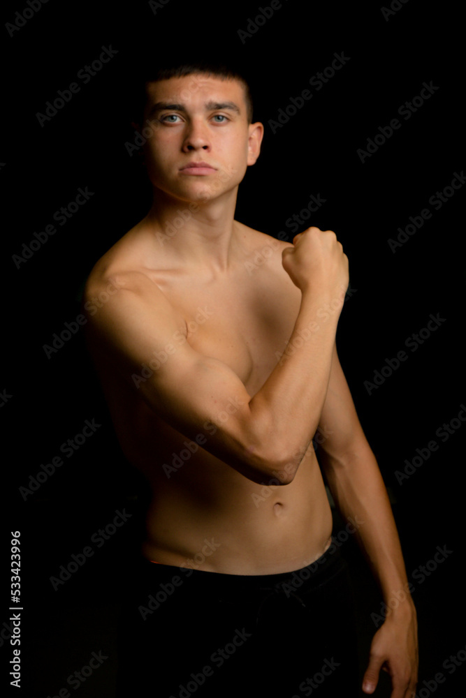 Nineteen year old teen boy flexing his arm muscles Nineteen year old teen boy flexing his arm muscles