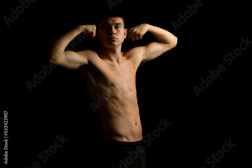 Nineteen year old teen boy flexing his arms © Ben Gingell