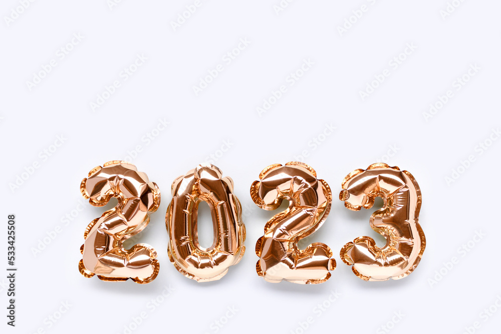 2023 gold inflatable balloons on a blue pastel background with place for text. New Year's festive composition.