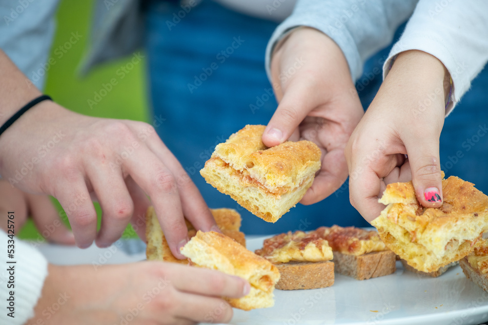 Children eating fig jam on slices of bread outdoor.