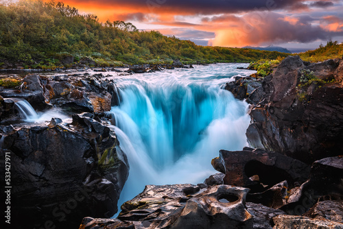 Scenic image of Iceland. Great view on waterfall with colorful sky during sunset. Wonderful Nature landscape. Travel is a Lifestyle, concept. Iceland popular place of travel and touristic location.