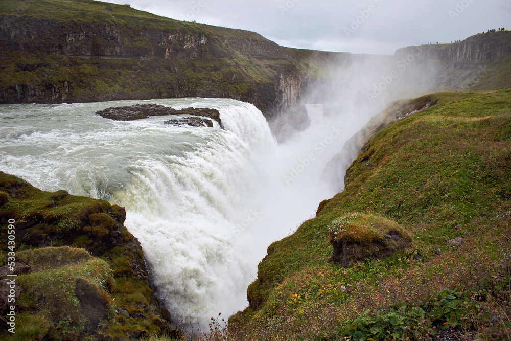 Gullfoss falls. Waterfall in green rocky landscape, Iceland, Europe. Gullfoss falls. Waterfall in green rocky landscape, Iceland, Europe.