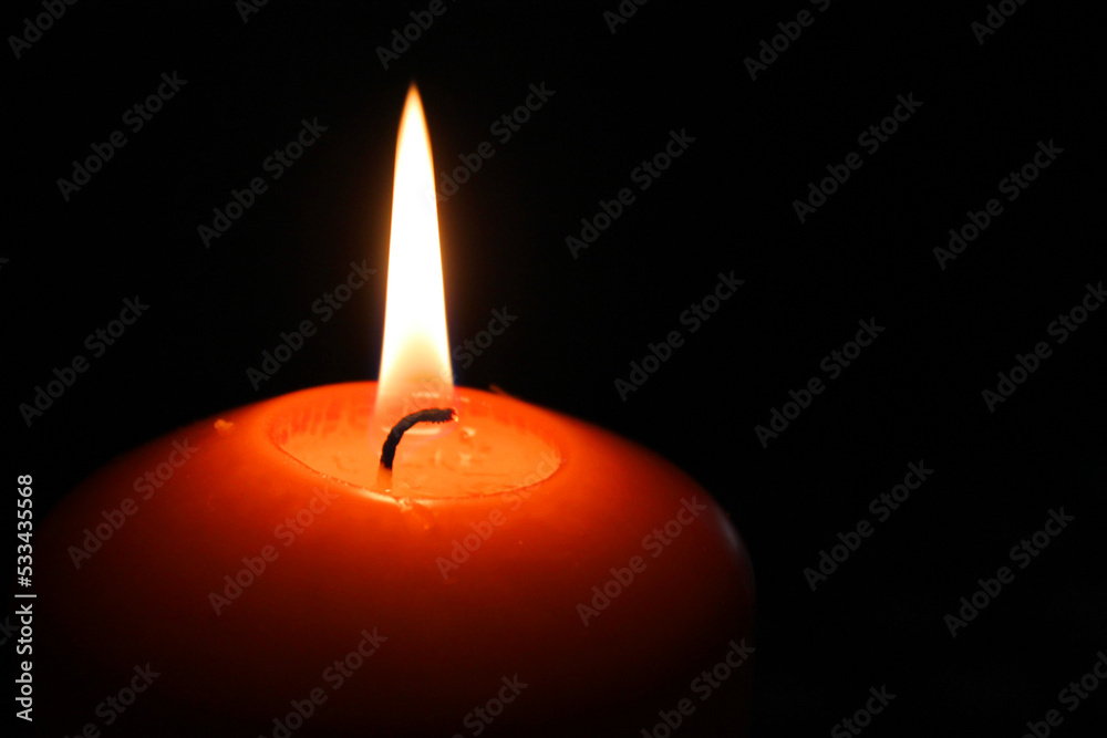 Red candle light with burning flame in the darkness Red candle light with burning flame in the darkness