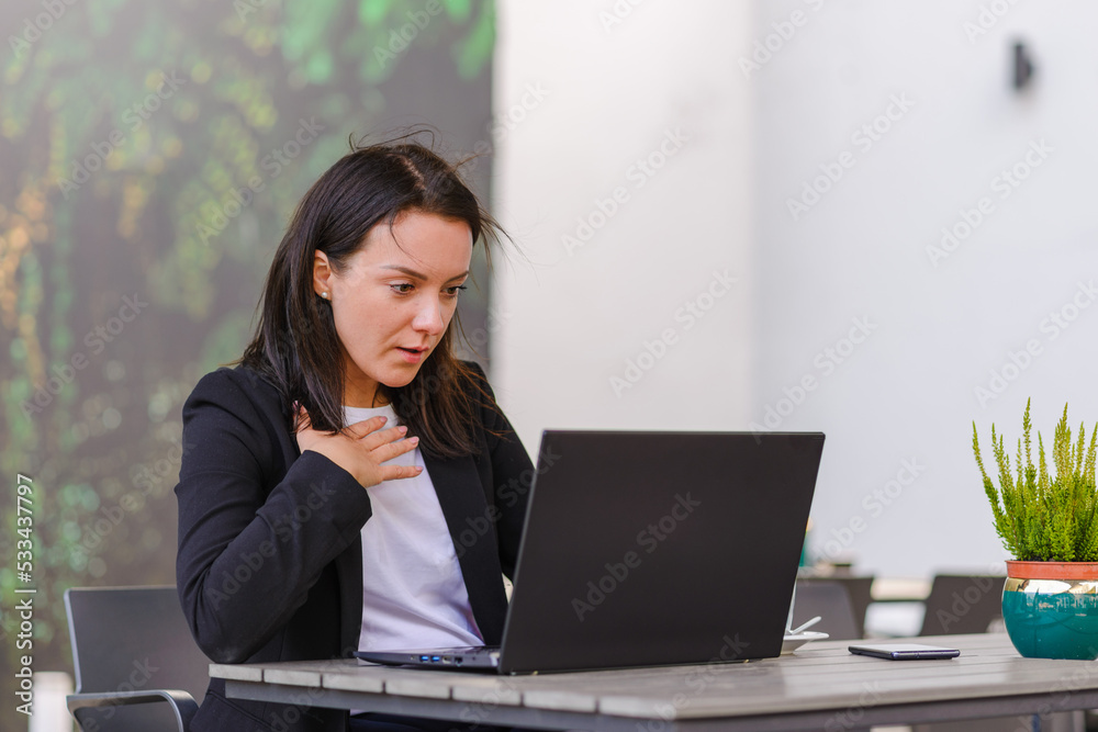 Impressed,shocked,surprised caucasian business woman student freelancer using laptop,watching comedy,reading news, surfing internet social media online in the city cafe outdoors. Impressed,shocked,surprised caucasian business woman student freelancer using laptop,watching comedy,reading news, surfing internet social media online in the city cafe outdoors.
