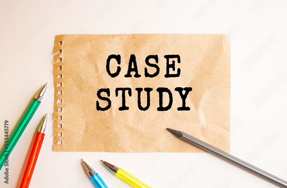 A sheet of kraft paper torn from a notebook lies on the table. Text on CASE STUDY sheet. Colored pens and a pencil. A sheet of kraft paper torn from a notebook lies on the table. Text on CASE STUDY sheet. Colored pens and a pencil.