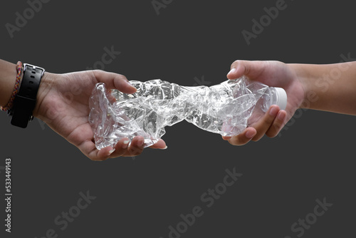 Giving twisted plastic bottle to make recyclying, reusing and reducing objects to lower garbage and to keep our environment clean and clear to everyone concept, soft and selective focus.