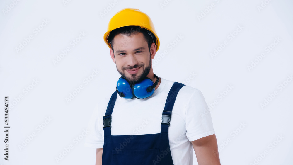 smiling foreman in overalls and helmet looking at camera isolated on white.