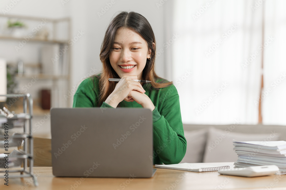 Young cheery happy positive asian woman sit indoors and using laptop, relax time. Young cheery happy positive asian woman sit indoors and using laptop, relax time.
