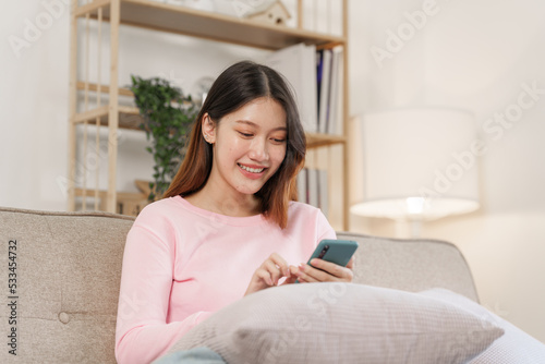 Happy young attractive smiling asian woman enjoying relax time at apartment.
