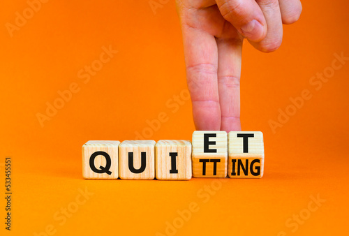 Quiet quitting symbol. Concept words Quiet quitting on wooden cubes. Businessman hand. Beautiful orange table orange background. Business quiet quitting concept. Copy space. photo
