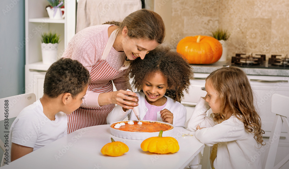 The child helps the mother to cook pumpkin pie. An American family. The child helps the mother to cook pumpkin pie. An American family.