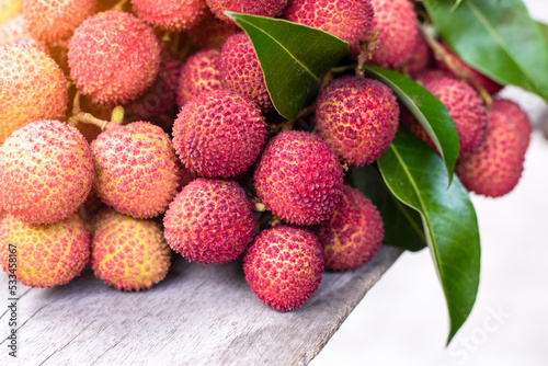 Bunch of fresh ripe lychees with green leaves in that , sweet and sour fruit tase, healthy fruit juice, winter seasonal fruit in Thailand, red fruit color