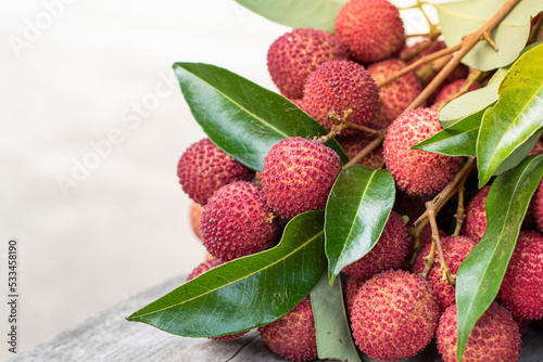 Bunch of fresh ripe lychees with green leaves in that , sweet and sour fruit tase, healthy fruit juice, winter seasonal fruit in Thailand, red fruit color