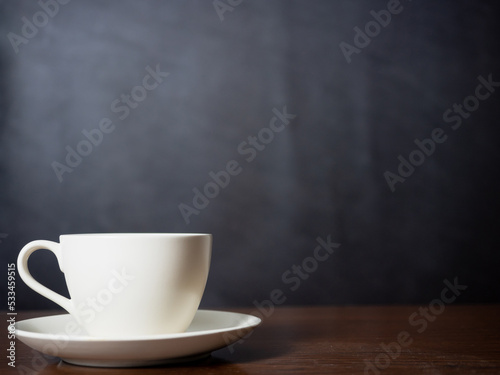 Close up white coffee cup on wood table dark background