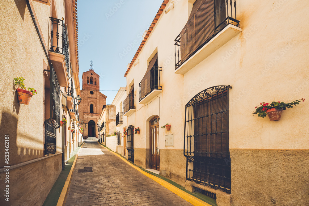 Church Street in the village of Lubrin, where the perspective leads the view to the door under the bell tower of the church.