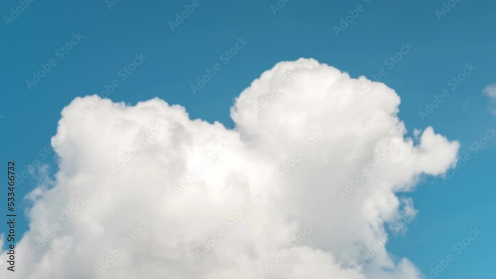 fluffy clouds on a clear light blue sky. Overall plan fluffy clouds on a clear light blue sky. Overall plan