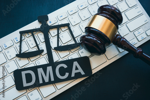 Plate with DMCA Digital Millennium Copyright Act sign, gavel and keyboard. photo