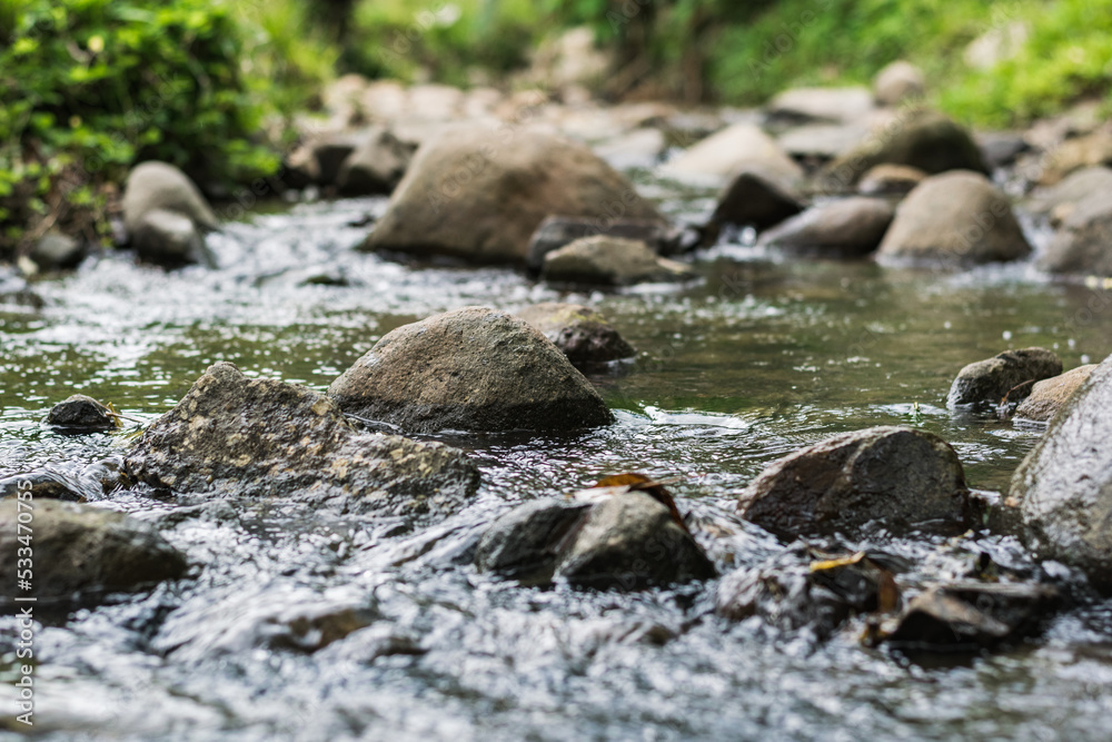 crystal clear water stream full of stones and surrounded by grass, running through the beautiful Colombian mountains. water resource coming out of the top of a snowy mountain. crystal clear water stream full of stones and surrounded by grass, running through the beautiful Colombian mountains. water resource coming out of the top of a snowy mountain.