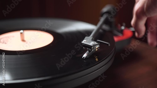 man starts a vintage vinyl player in a cozy room. close-up.