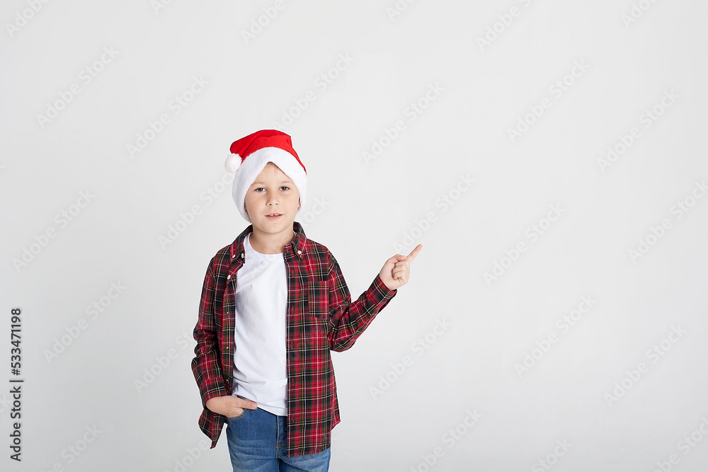 Smiling little boy in Santa's hat with gift box, isolated on white.
