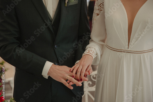 bride and groom showing their rings photo