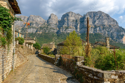 view of traditional architecture with stone buildings and background astraka mountain during fall season in the picturesque village of papigo , zagori Greece	
