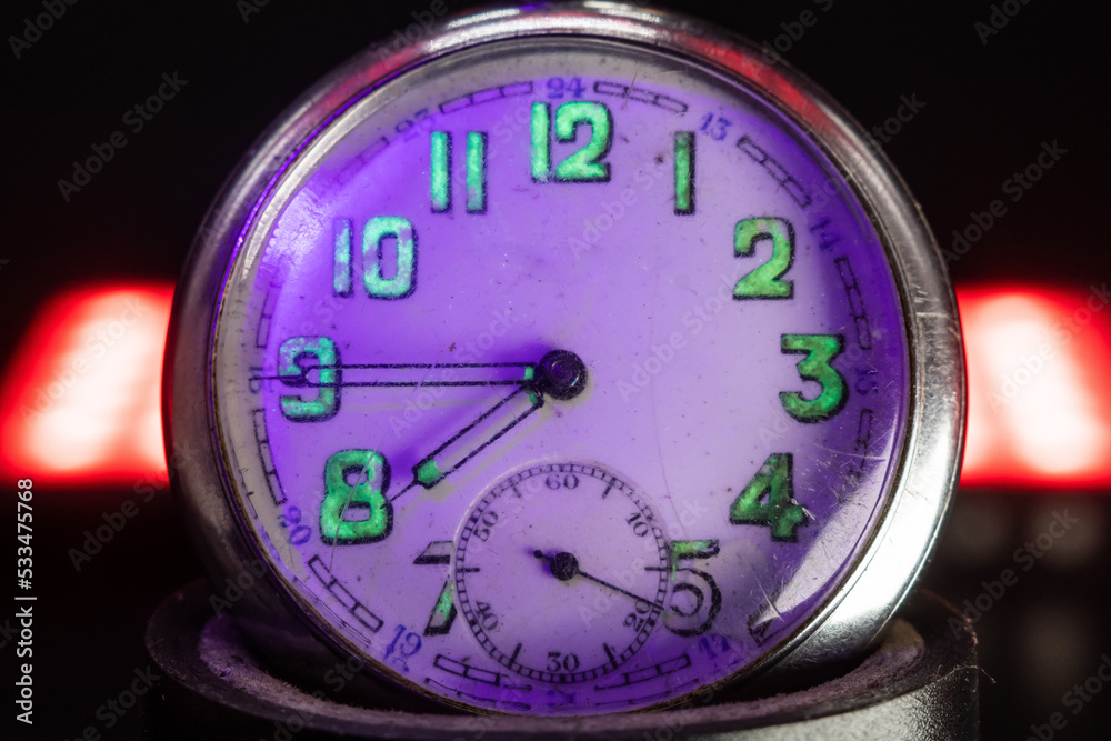 An old pocket watch with dangerous radioactive fluorescent paint. Scratches on the glass. Silver