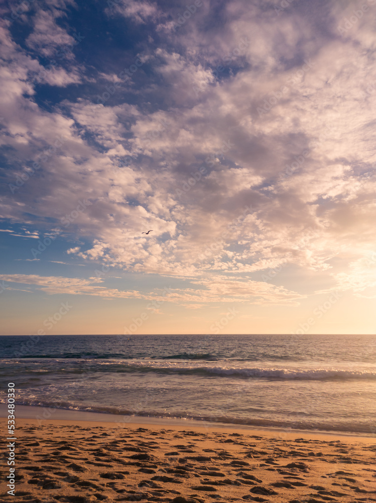 Scenic sunset sky over wavy sea with sandy coast Scenic sunset sky over wavy sea with sandy coast
