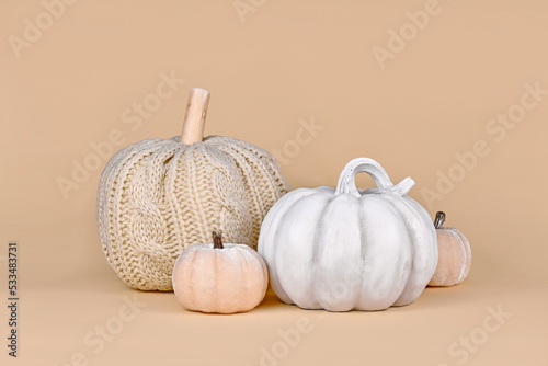 Autumn decoration with boho style knitted beige pumpkin and gray stone pumpkin