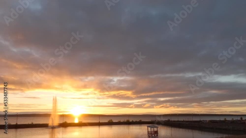 Sunrise with water fountains and moving clouds on a beach in Haileybury, Temiskaming Shores, Ontario, Canada photo