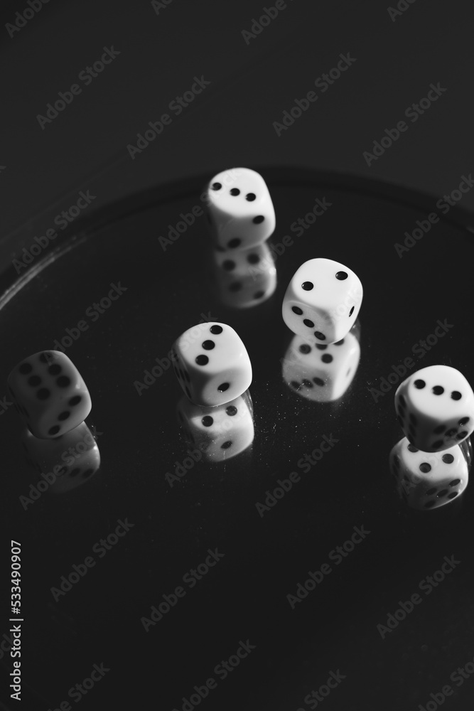 Playing dice on glass with reflections in it. Black and white photo Playing dice on glass with reflections in it. Black and white photo