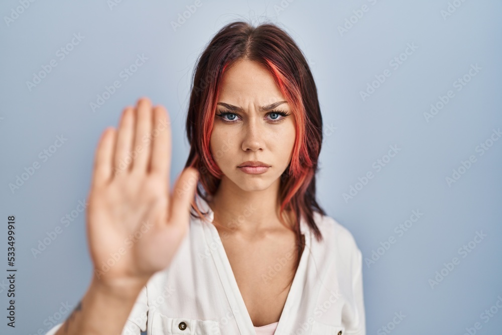 Young caucasian woman wearing casual white shirt over isolated background doing stop sing with palm of the hand. warning expression with negative and serious gesture on the face. Young caucasian woman wearing casual white shirt over isolated background doing stop sing with palm of the hand. warning expression with negative and serious gesture on the face.